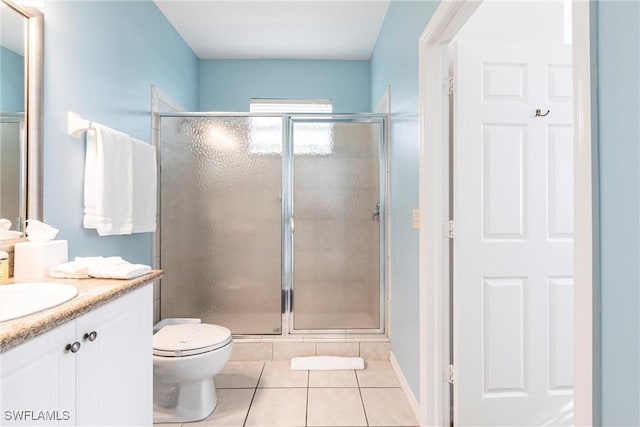 bathroom with toilet, tile patterned flooring, walk in shower, and vanity