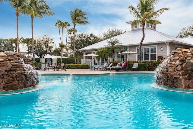 view of swimming pool featuring pool water feature and a patio