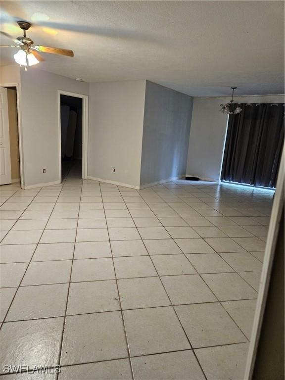 tiled spare room featuring ceiling fan