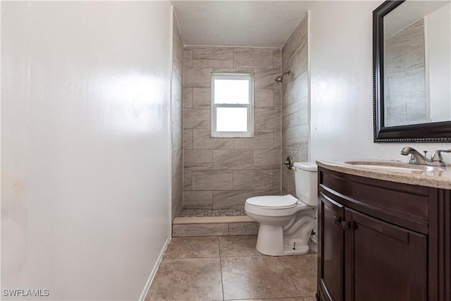 bathroom with tiled shower, vanity, and toilet