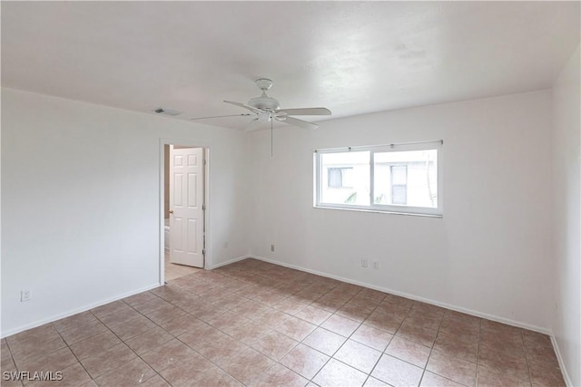 tiled spare room with ceiling fan