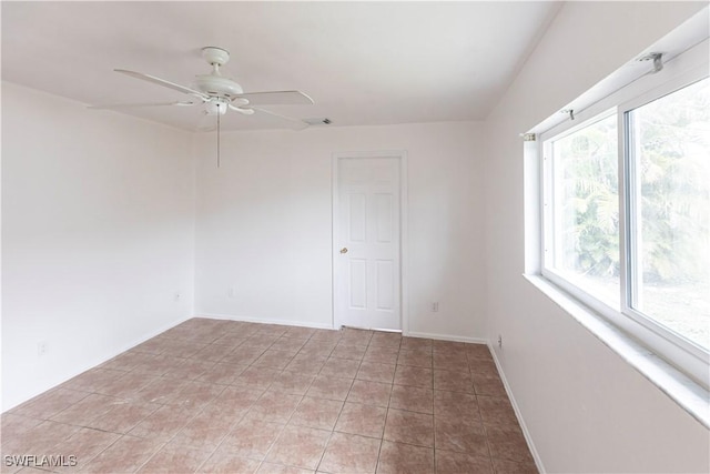 tiled spare room with ceiling fan