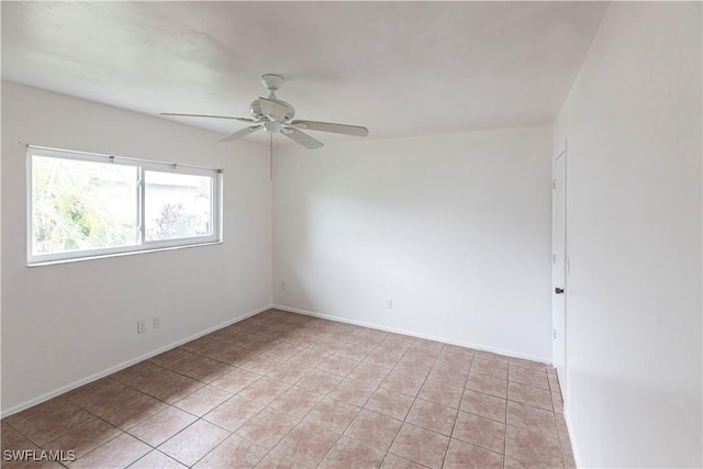 empty room with ceiling fan and light tile patterned floors