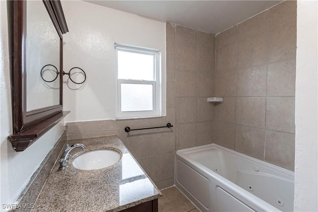 bathroom with a washtub, vanity, and tile patterned floors