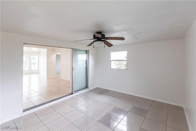 tiled spare room with ceiling fan