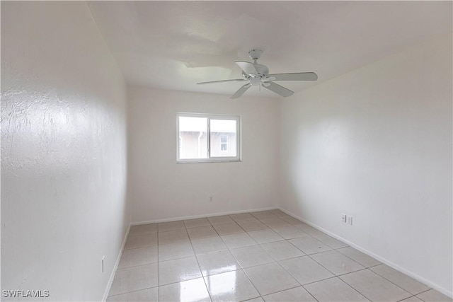 tiled spare room with ceiling fan