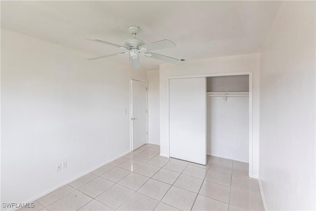 unfurnished bedroom with light tile patterned floors, ceiling fan, and a closet