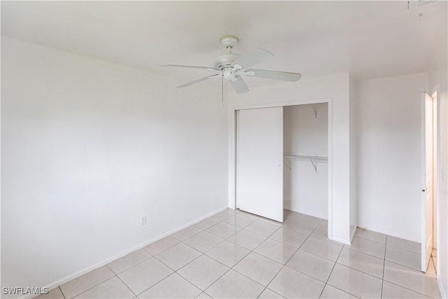 unfurnished bedroom with light tile patterned flooring, ceiling fan, and a closet