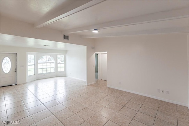 spare room featuring light tile patterned flooring and beam ceiling