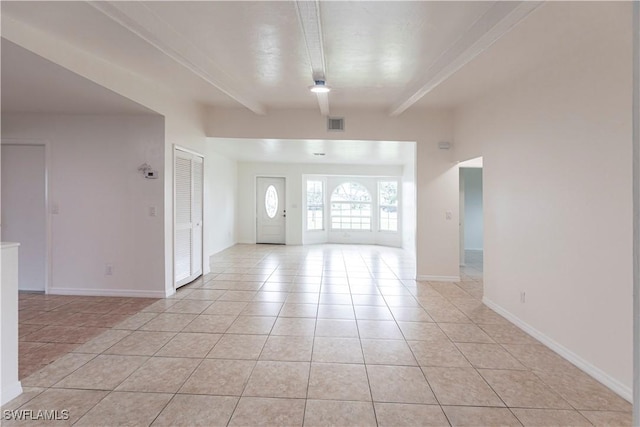 tiled foyer entrance featuring beam ceiling