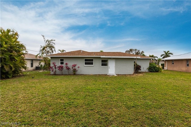 back of house featuring central AC unit and a yard