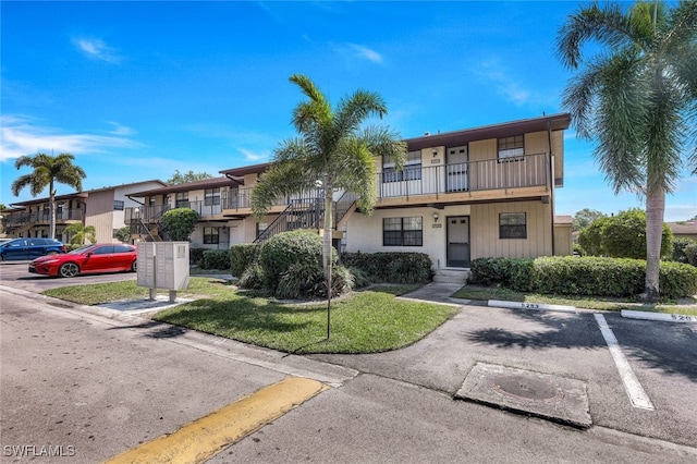 view of front of home featuring a balcony and a front yard