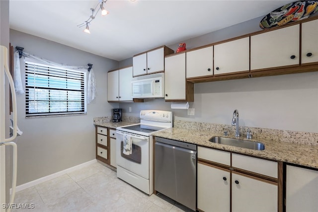 kitchen with sink, white cabinetry, light stone counters, white appliances, and rail lighting