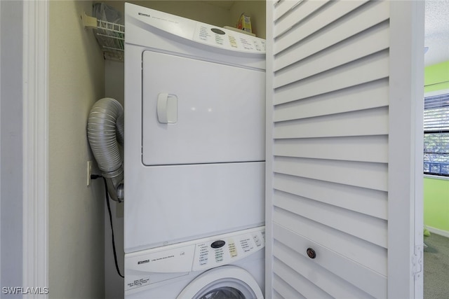 clothes washing area with a textured ceiling and stacked washer / drying machine