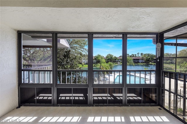 unfurnished sunroom with a water view