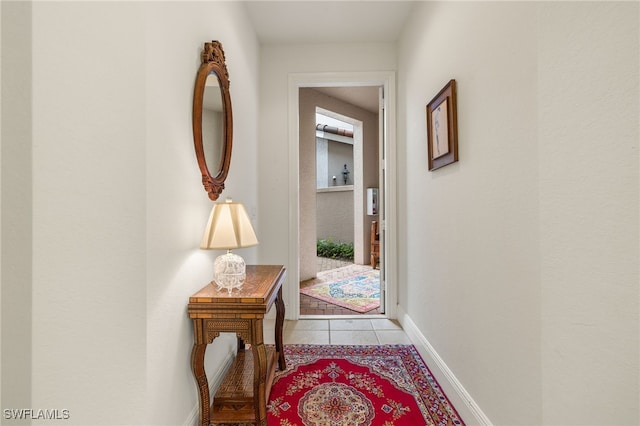 hall with tile patterned flooring and baseboards