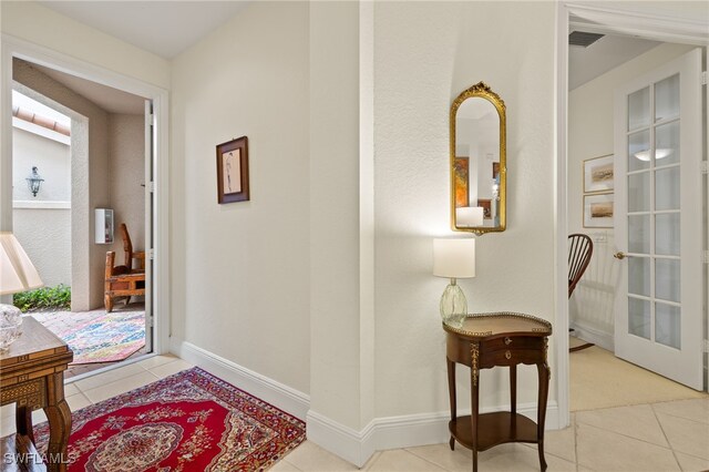 entryway featuring light tile patterned floors and french doors