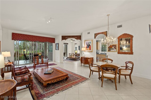 living room featuring ceiling fan with notable chandelier and light tile patterned floors