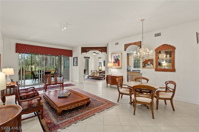 living area with light tile patterned floors, arched walkways, visible vents, and baseboards