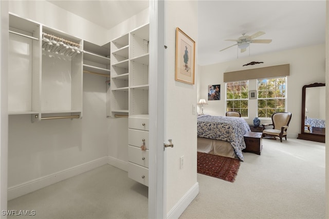 spacious closet with light colored carpet and ceiling fan