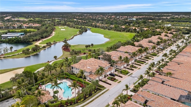 drone / aerial view with view of golf course and a water view