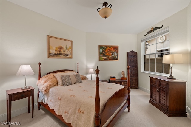 bedroom with baseboards and light colored carpet