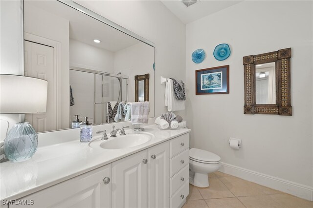 bathroom featuring vanity, toilet, a shower with shower door, and tile patterned flooring