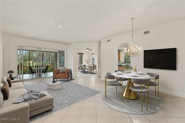 living area featuring arched walkways, tile patterned flooring, visible vents, and baseboards