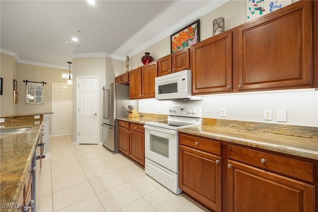 kitchen with hanging light fixtures, light stone countertops, white appliances, light tile patterned floors, and crown molding