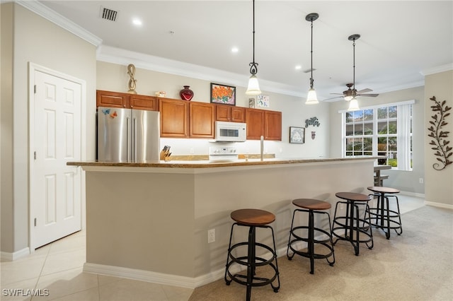 kitchen with white appliances, a kitchen island with sink, and crown molding