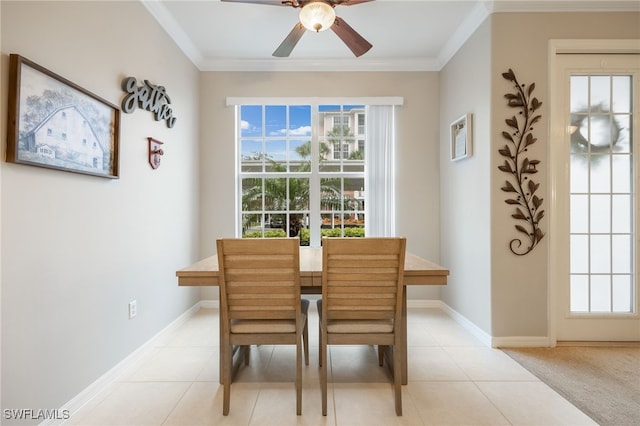 tiled dining area with ceiling fan and ornamental molding