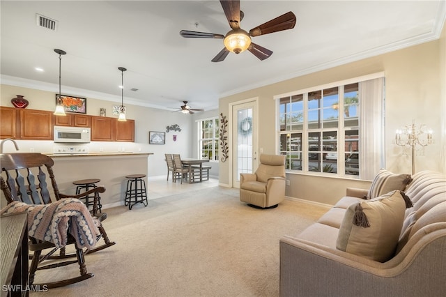 carpeted living room featuring ceiling fan and ornamental molding