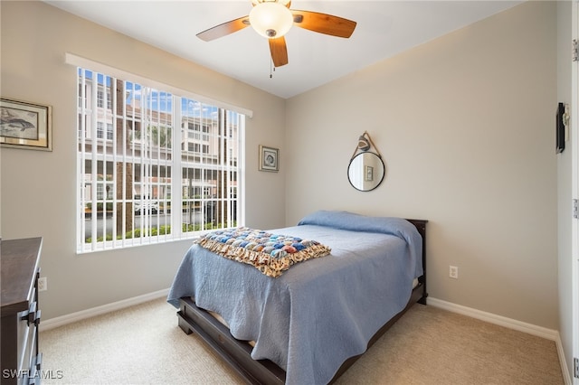 bedroom with multiple windows, ceiling fan, and light colored carpet