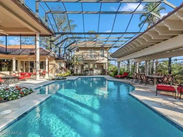 view of pool featuring outdoor lounge area, a patio area, and glass enclosure