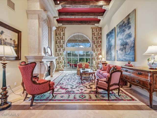 sitting room featuring tile patterned flooring, a towering ceiling, and beamed ceiling