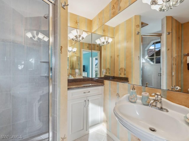 bathroom with an enclosed shower, sink, tile patterned flooring, and a chandelier