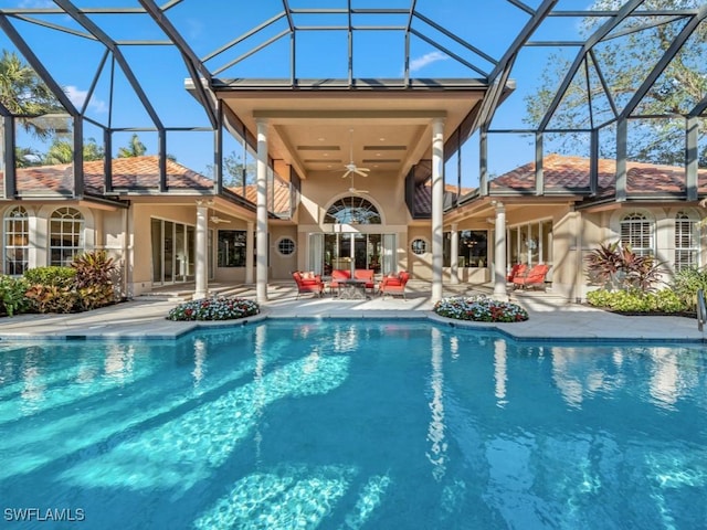 view of swimming pool featuring a patio area, ceiling fan, and glass enclosure