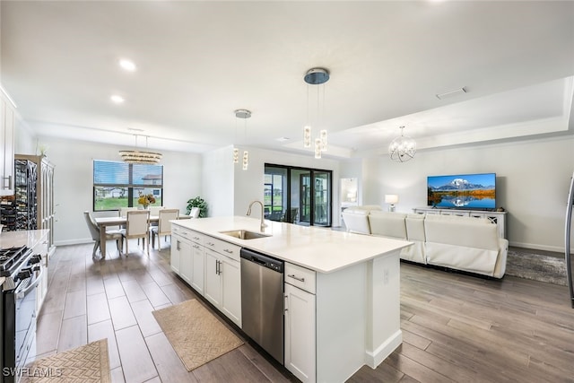 kitchen featuring sink, white cabinets, decorative light fixtures, an island with sink, and stainless steel appliances