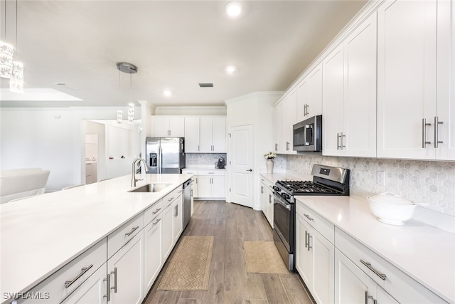 kitchen with decorative light fixtures, white cabinets, and stainless steel appliances