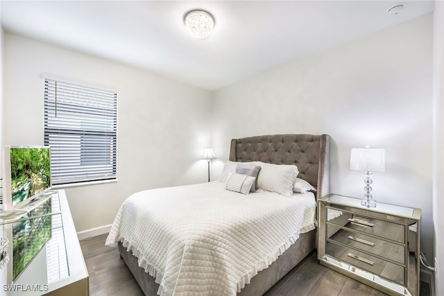 bedroom with dark hardwood / wood-style flooring and multiple windows