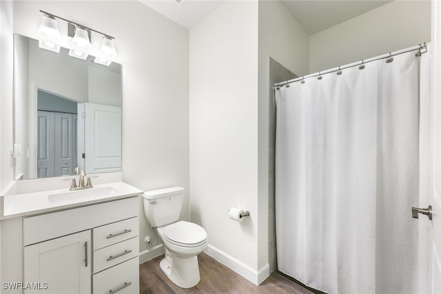 bathroom with hardwood / wood-style floors, toilet, a shower with shower curtain, and vanity