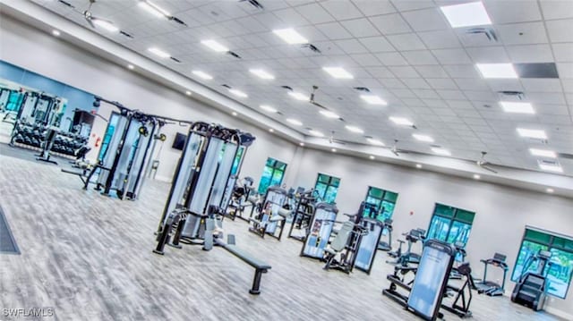 gym with a drop ceiling and a towering ceiling