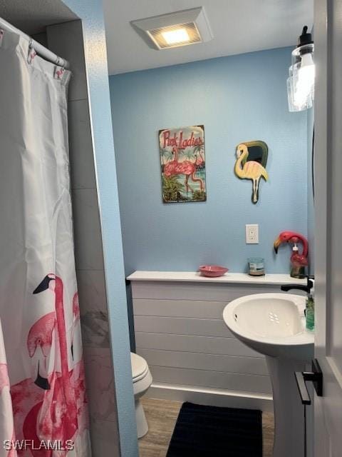 bathroom featuring curtained shower, visible vents, toilet, and wood finished floors