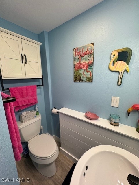 half bathroom featuring toilet and wood finished floors