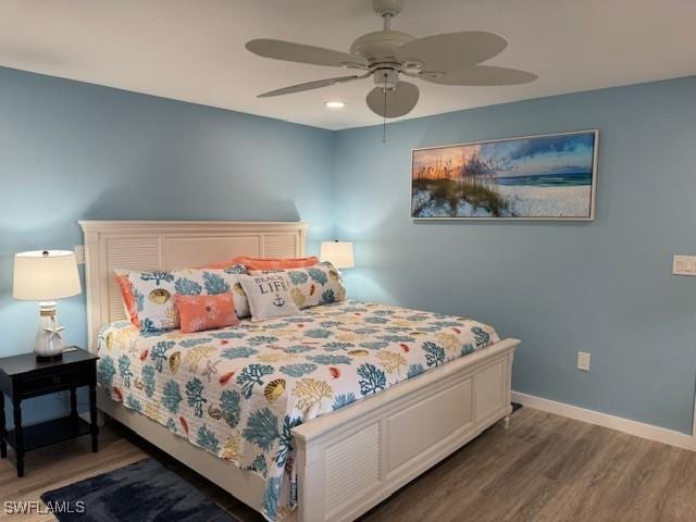 bedroom featuring wood finished floors, a ceiling fan, and baseboards