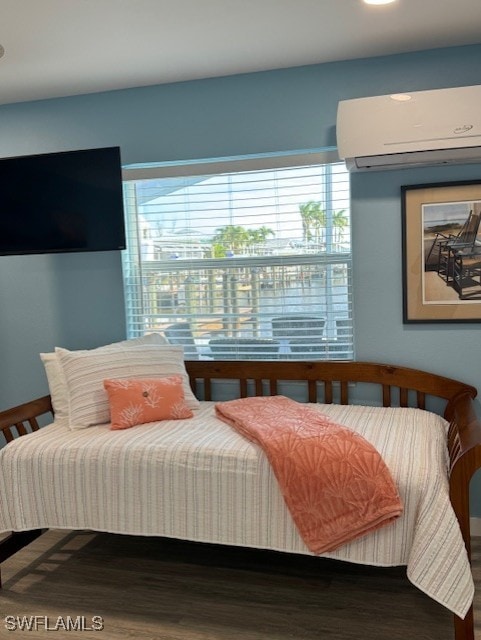 bedroom featuring an AC wall unit and wood finished floors