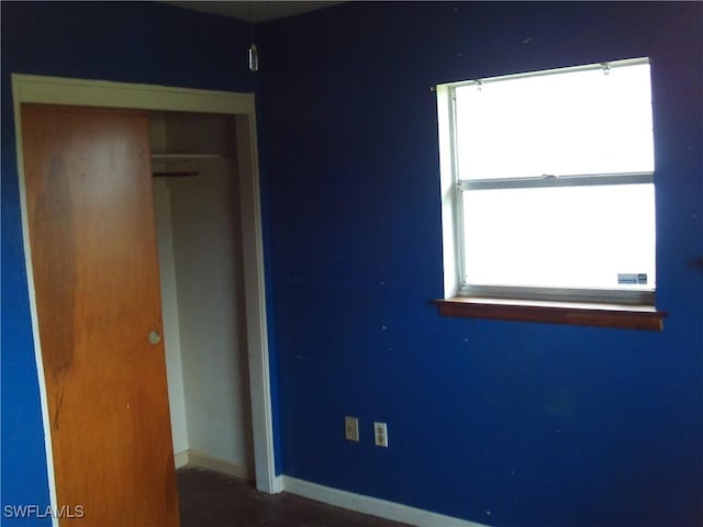 unfurnished bedroom with a closet and multiple windows