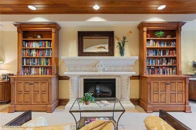 living area featuring a premium fireplace, light colored carpet, and wooden ceiling