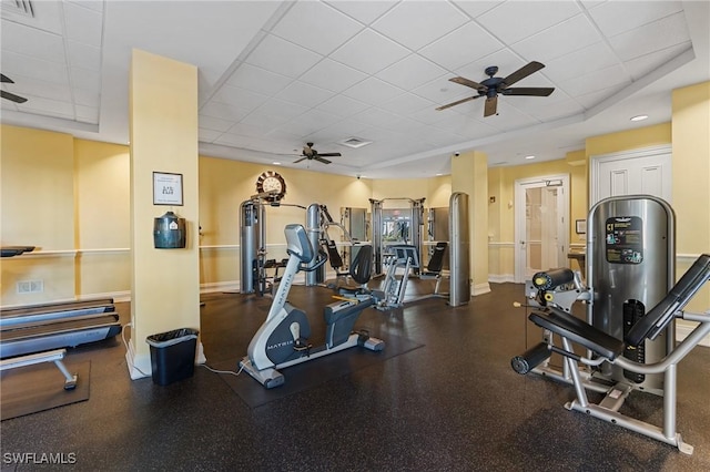 gym featuring ceiling fan and a drop ceiling