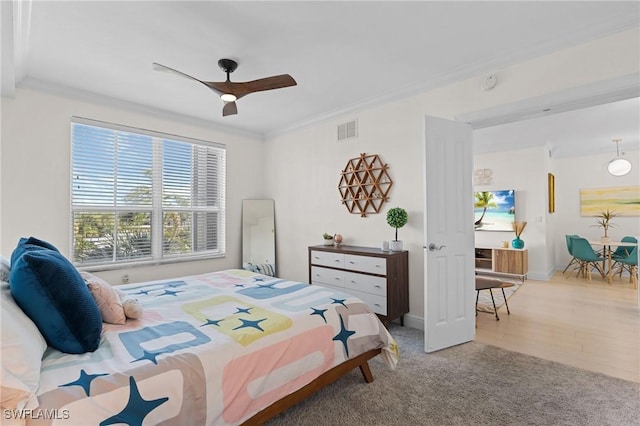 carpeted bedroom with crown molding and ceiling fan